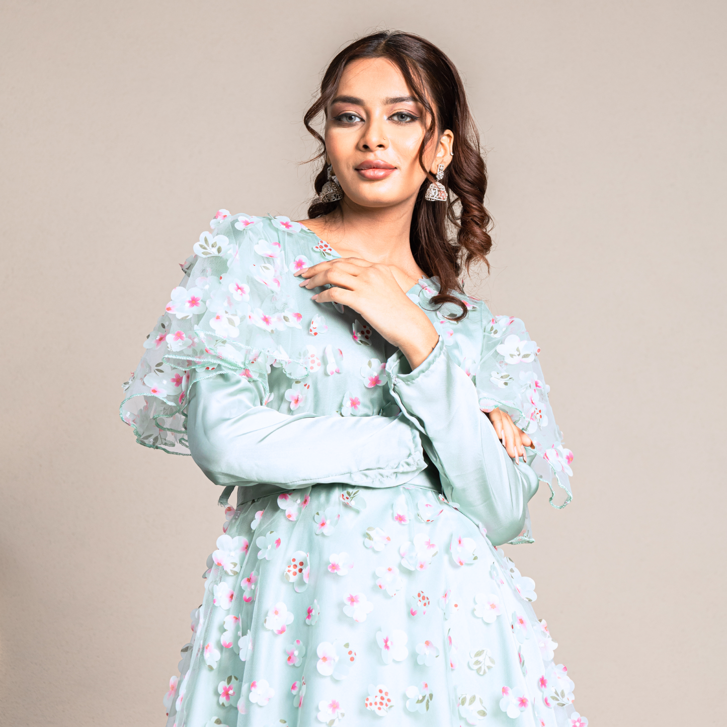 Multi-layered gown with cancan, satin silk, and 3D floral net for a voluminous silhouette. Square neckline aqua gown with a sheer embroidered floral net overlay
