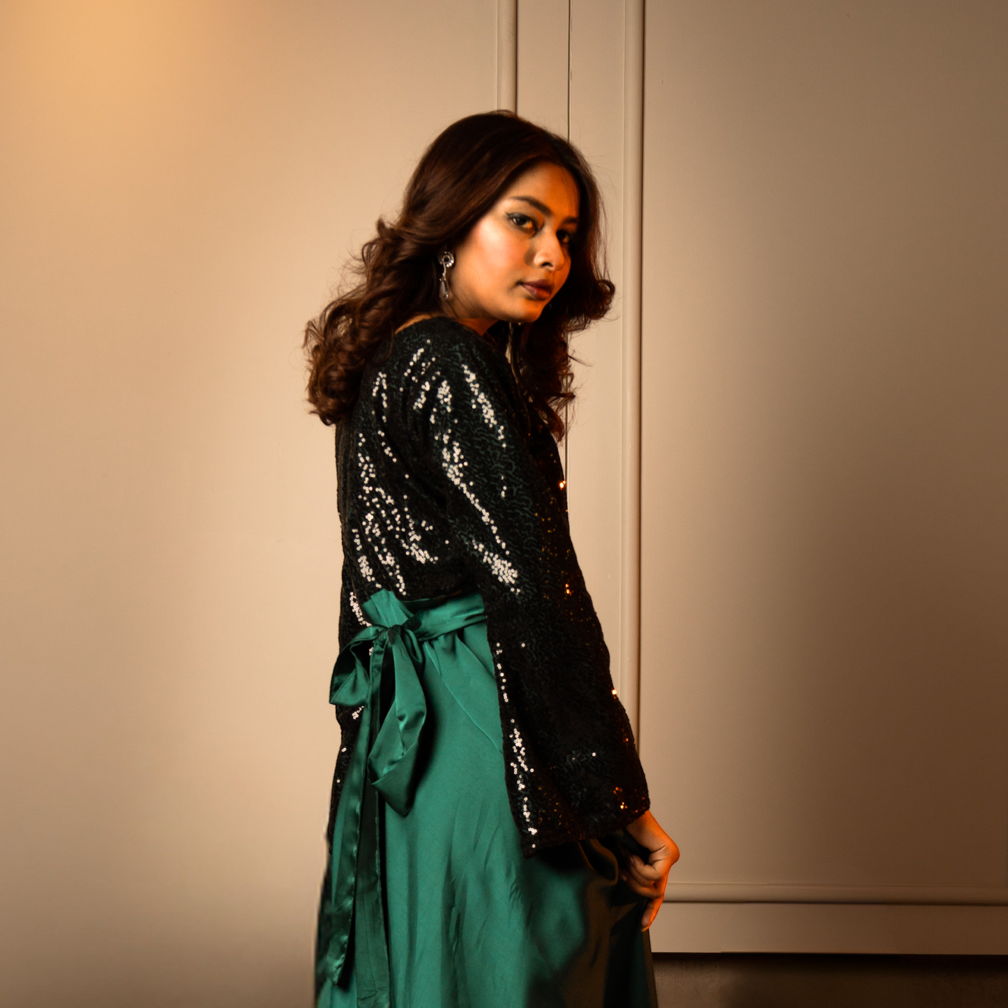 Emerald evening gown with a zip-up back, tie-up belt, and black net detailing for a graceful silhouette.